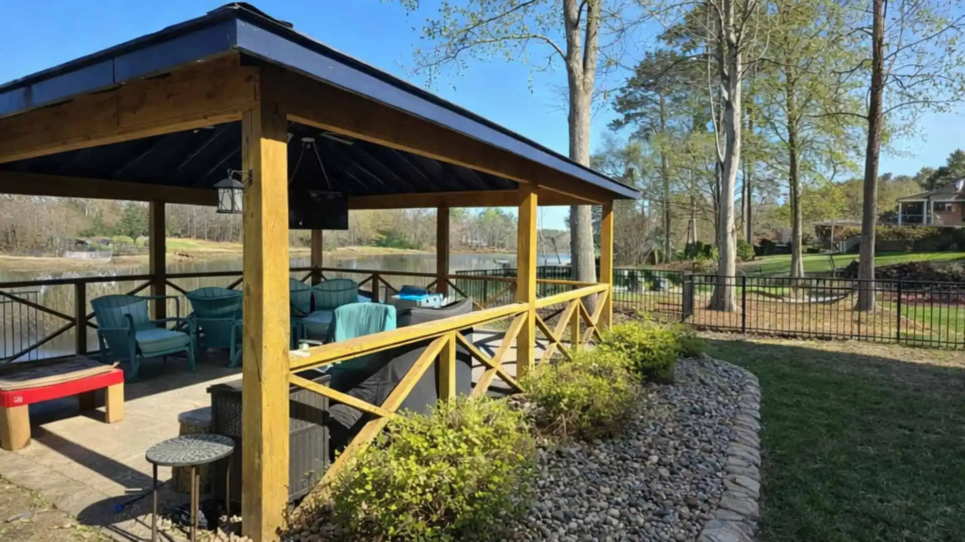 Covered outdoor pavilion with seating, surrounded by lush landscaping and well-maintained lawn.