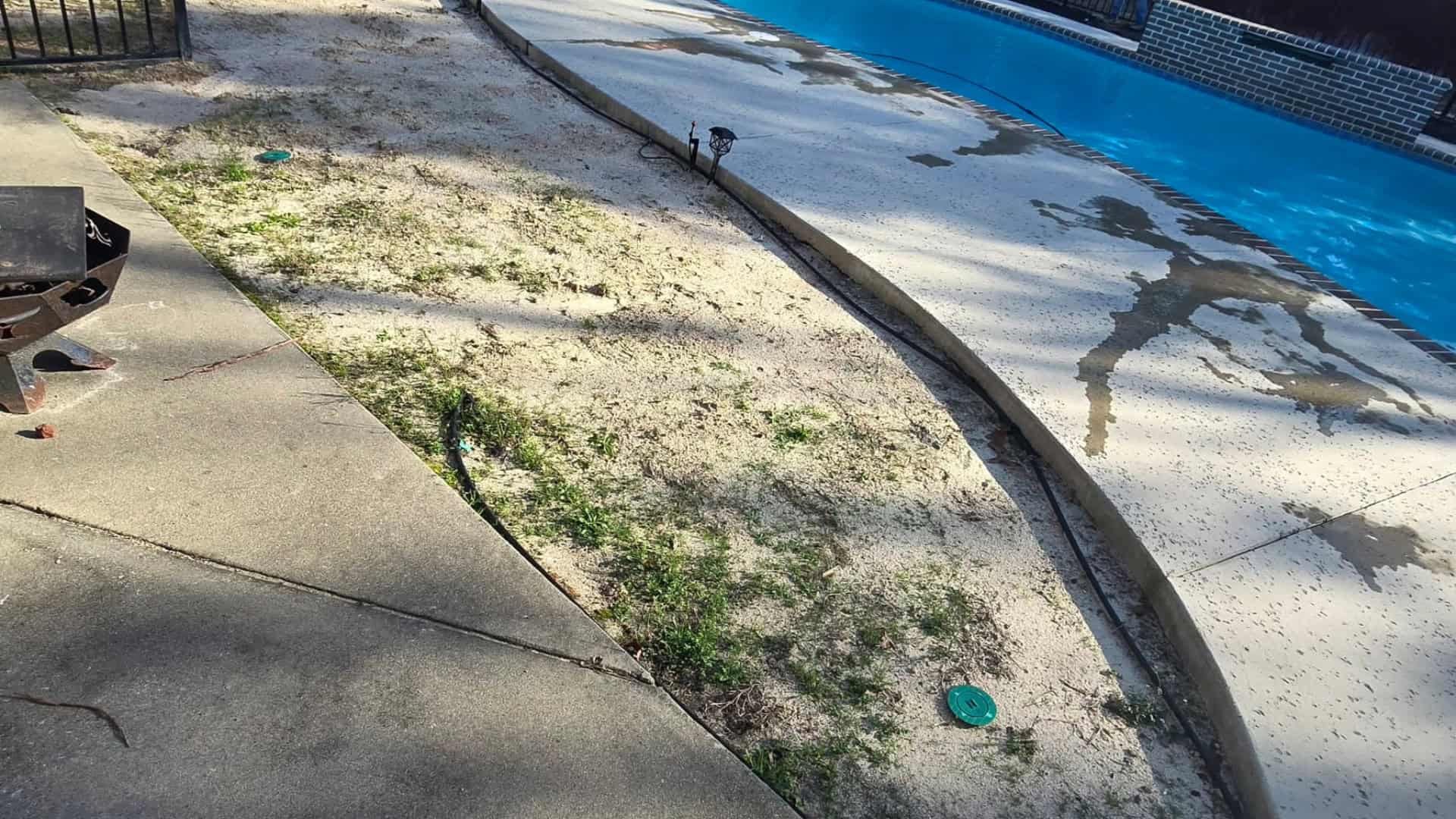 Damaged lawn and landscape area near swimming pool, requiring landscaping services.